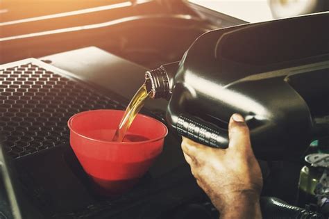 Premium Photo Car Mechanic Replacing With Pouring Oil Into Engine