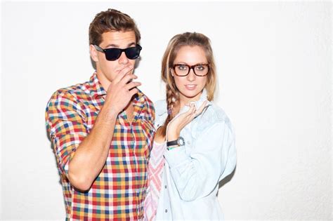 Smoking Tobacco And Portrait Of Hipster Couple With White Wall