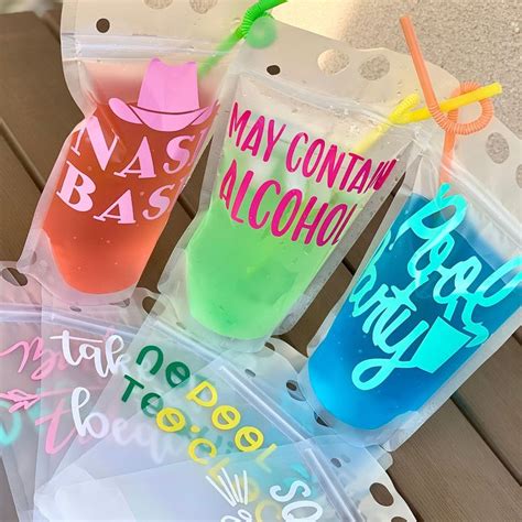 Three Different Colored Drinks In Plastic Bags With Straws