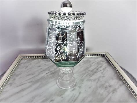 A Glass Jar Sitting On Top Of A Marble Table Next To A Silver Tray With