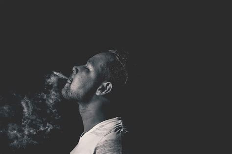 Premium Photo Side View Of Man Smoking Cigarette Against Black Background