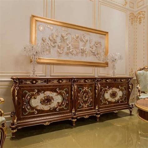 An Ornately Decorated Sideboard In The Middle Of A Room With Gold Trimming