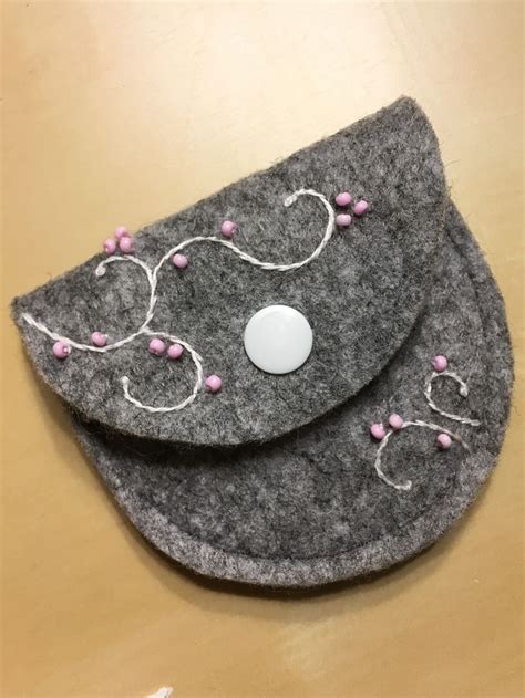 Two Gray Felt Purses Sitting On Top Of A Wooden Table Next To Each Other