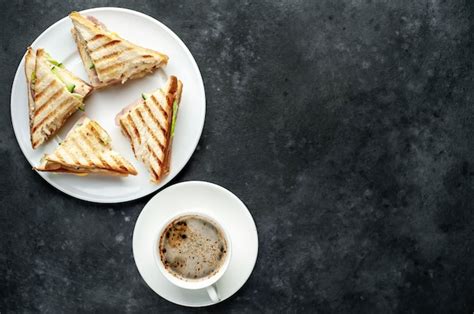 Café y sandwiches con jamón queso tomate lechuga y pan tostado