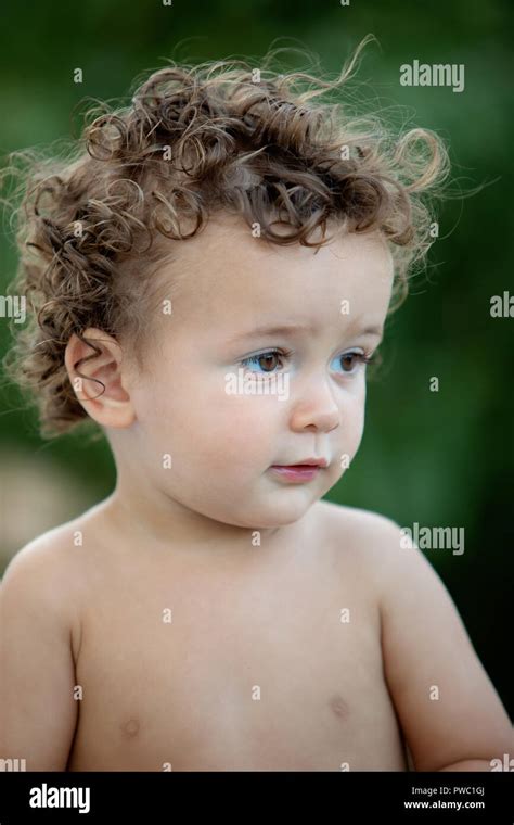 Beautiful Baby With Curly Hair In The Garden Without T Shirt Stock