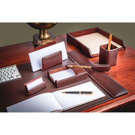 An Office Desk With Notepads Pen And Pencil Holder On Top Of It