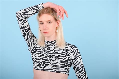 Joven gay de años con maquillaje aislado en un retrato de estudio de fondo coloreado gente
