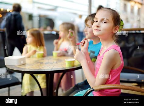 Cute Little Children Eating Tasty Fresh Ice Cream In Outdoor Cafe Kids