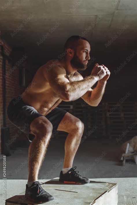 Caucasian Half Naked Male Athlete Is Performing Box Jumps On Gymnastic