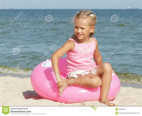 A Menina Senta Se Em Um C Rculo Para Nadar Perto Do Mar Foto De Stock