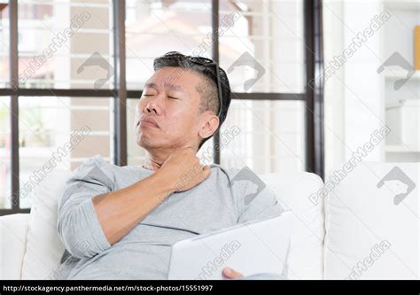 Mature Asian Man Shoulder Pain While Using Tablet Royalty Free Image