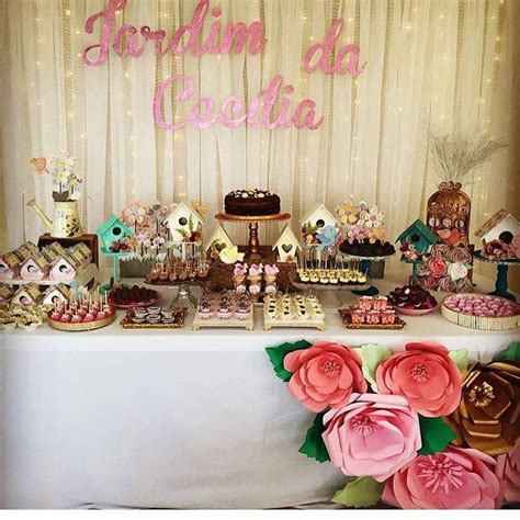 A Table Topped With Lots Of Desserts And Flowers