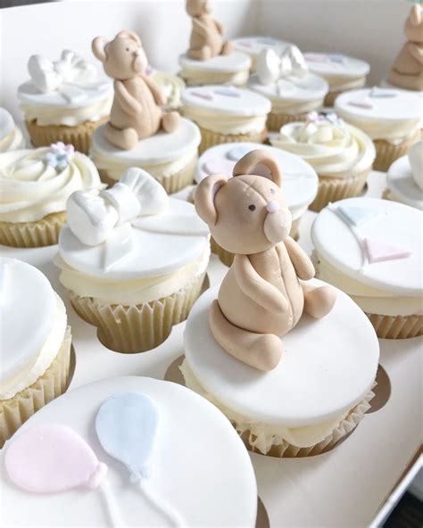 Cupcakes With White Frosting And Fondant Teddy Bears On Top Are In A Box