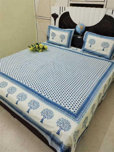 a blue and white bedspread with trees on it