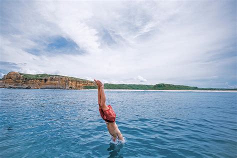 Shirtless Man Jumping Into Sea Against Cloudy Sky Photograph By Cavan