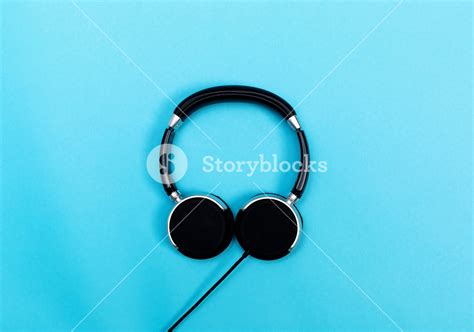 Pair Of Black Headphones On A Blue Background Royalty Free Stock Image