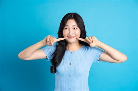 Premium Photo Portrait Of A Happy Smiling Asian Girl Posing On A Blue