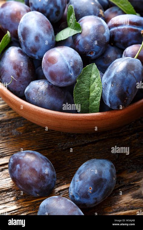 fresh crop of ripe organic plums in a plate on the table as background ...