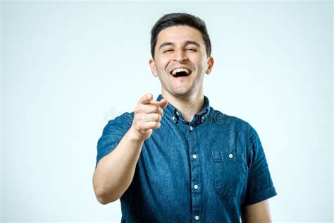 Homem Novo Feliz Do Retrato Rindo Apontando O Dedo Em Algum Foto