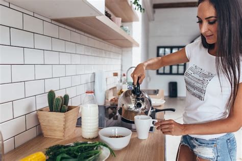 Premium Photo Woman Pouring Boiling Water Into A Cup From Kettle