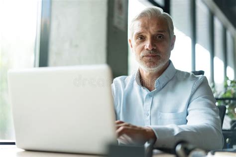 Happy Mature Professional Business Man Looking At Camera Sitting At