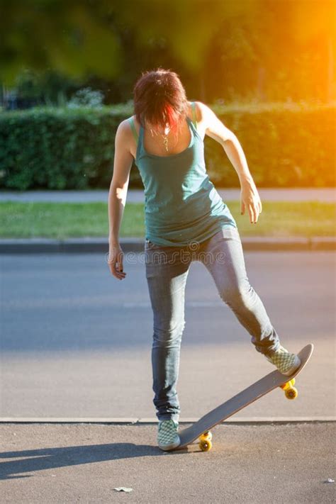 Young Skateboarder Girl Doing a Trick on Her Skateboard in Park ...