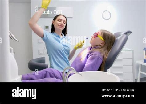 Dentist Presses Button And Raises Dental Chair To Treat Teeth Of Little