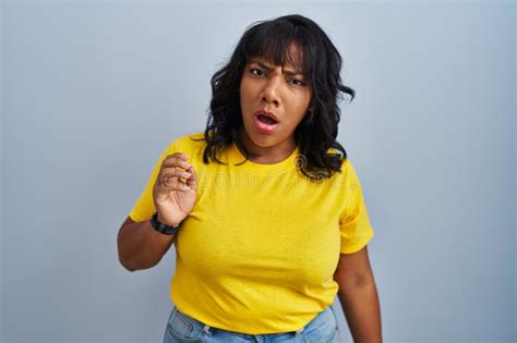 Hispanic Woman Standing Over Blue Background In Shock Face Looking Skeptical And Sarcastic