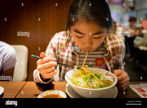 Girl Slurping Hot Ramen Noodle At A Restaurant Stock Photo Alamy