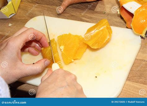 Cortar Una Naranja Pelada Con El Cuchillo Afilado Imagen De Archivo