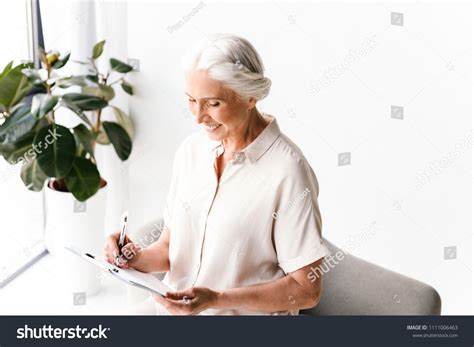 Smiling Mature Business Woman Taking Notes Stock Photo 1111006463