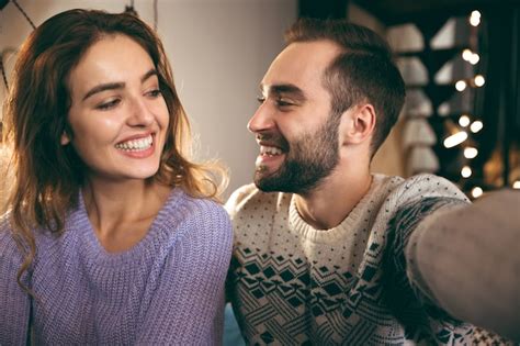 Premium Photo Cheerful Young Couple Sitting Together On A Couch At