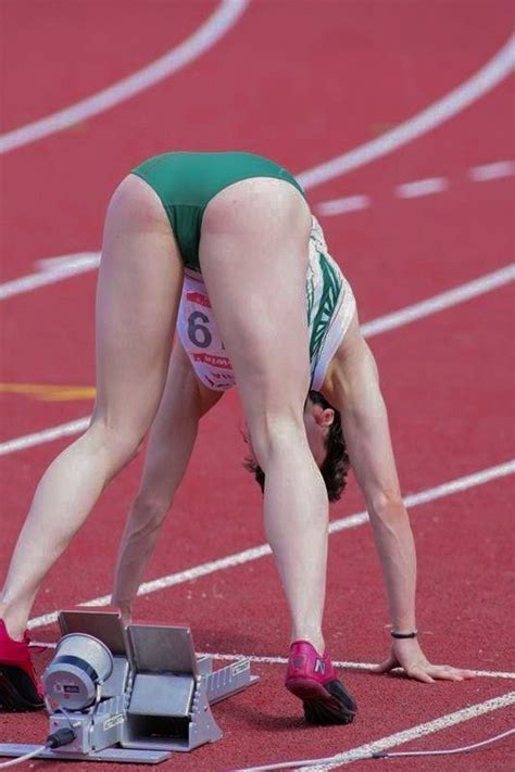 A Female Athlete Is Bending Over On The Track