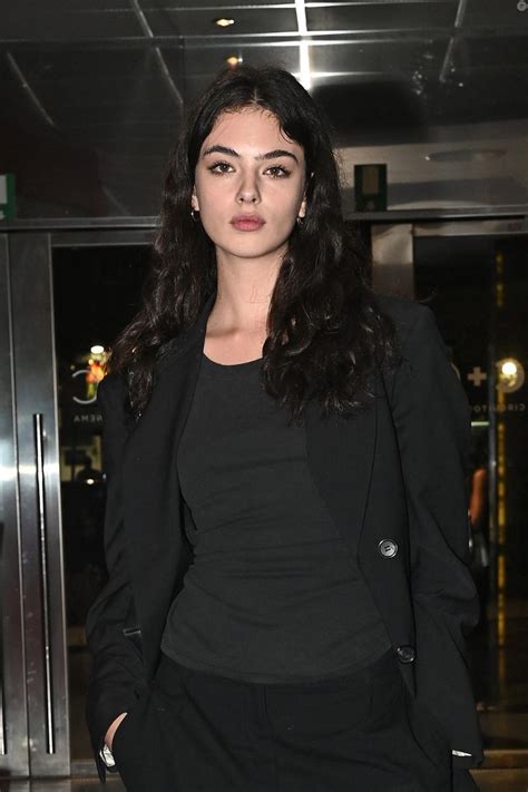 A Woman Standing In Front Of An Elevator Wearing A Black Top And Blazer