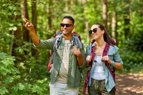 旅行、旅游、远足和人的概念 混血夫妇在森林里背着背包。亚历桑德拉·安布罗休合照高清摄影大图 千库网