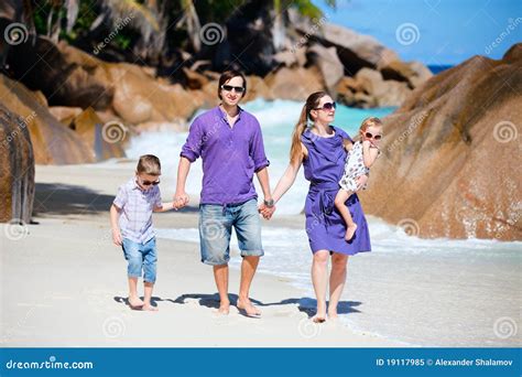 Familia Joven Que Recorre A Lo Largo De La Playa Imagen De Archivo