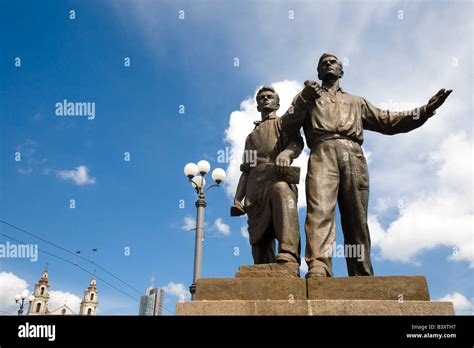 Two bronze Social Realism sculptures gesture boldly before buildings ...