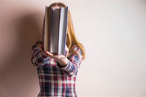 Free Photo Woman Holding Three Books In Front Of Her Face