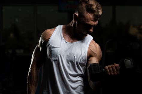 Premium Photo Man With Dumbbells Exercising Biceps