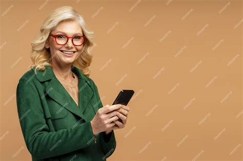 Premium Photo Smiling Mature Woman Wearing Eyeglasses Holding Mobile Phone Shopping Online