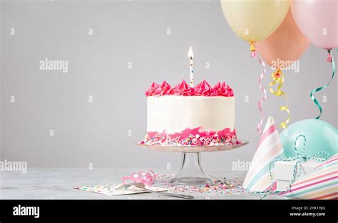 Pink Birthday Cake With Candle Presents Hats And Colorful Balloons