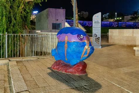 Night View Of A Decoratively Painted Abstract Stone Fish Sculpture On