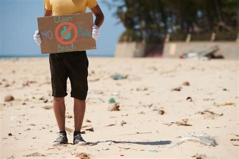 Imagem recortada de ativista em pé na praia suja praia limpa e sem