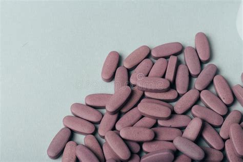 A Handful Of Oval Purple Tablets Lie On A Gray Background Stock Image