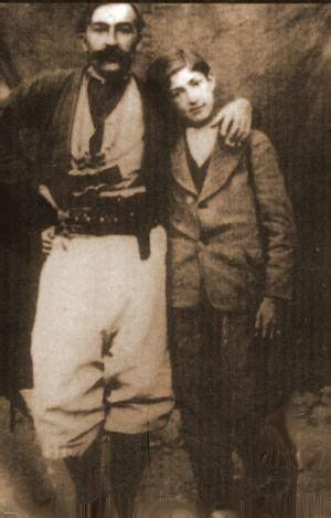 An Old Photo Of Two Men Standing Next To Each Other