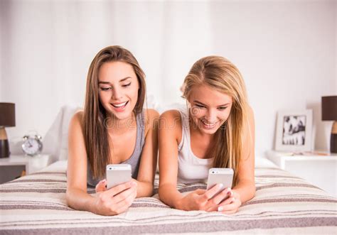 Amigos Femeninos Jovenes Sonrientes Que Mienten En Cama Foto De Archivo