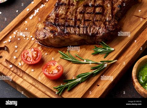 Grilled Black Angus Steak With Tomatoes Garlic With Rosemary On Meat