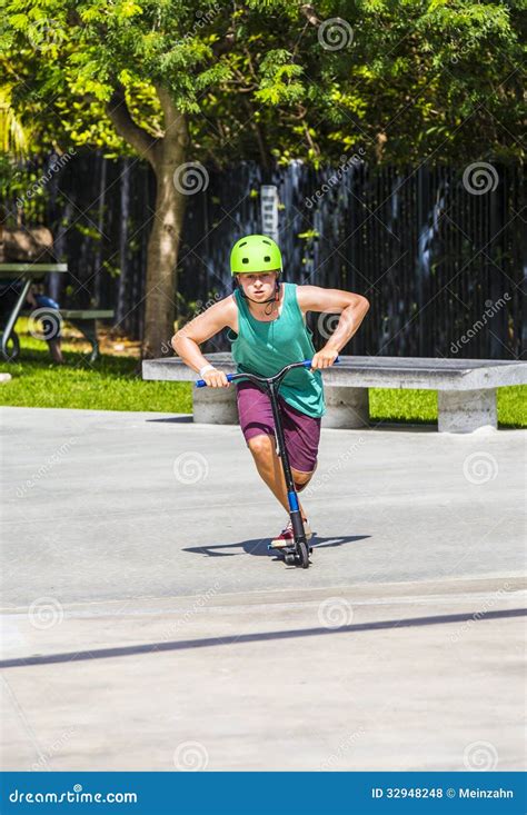 O Menino Tem O Divertimento Que Monta Seu Trotinette Do Impulso Foto