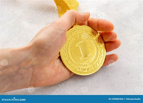 Hand Holding Gold Medal First Place Winner Of Competition Concept