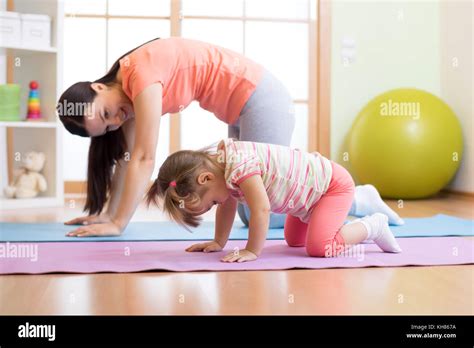 Mother and child daughter practicing yoga together at home. Sport and ...